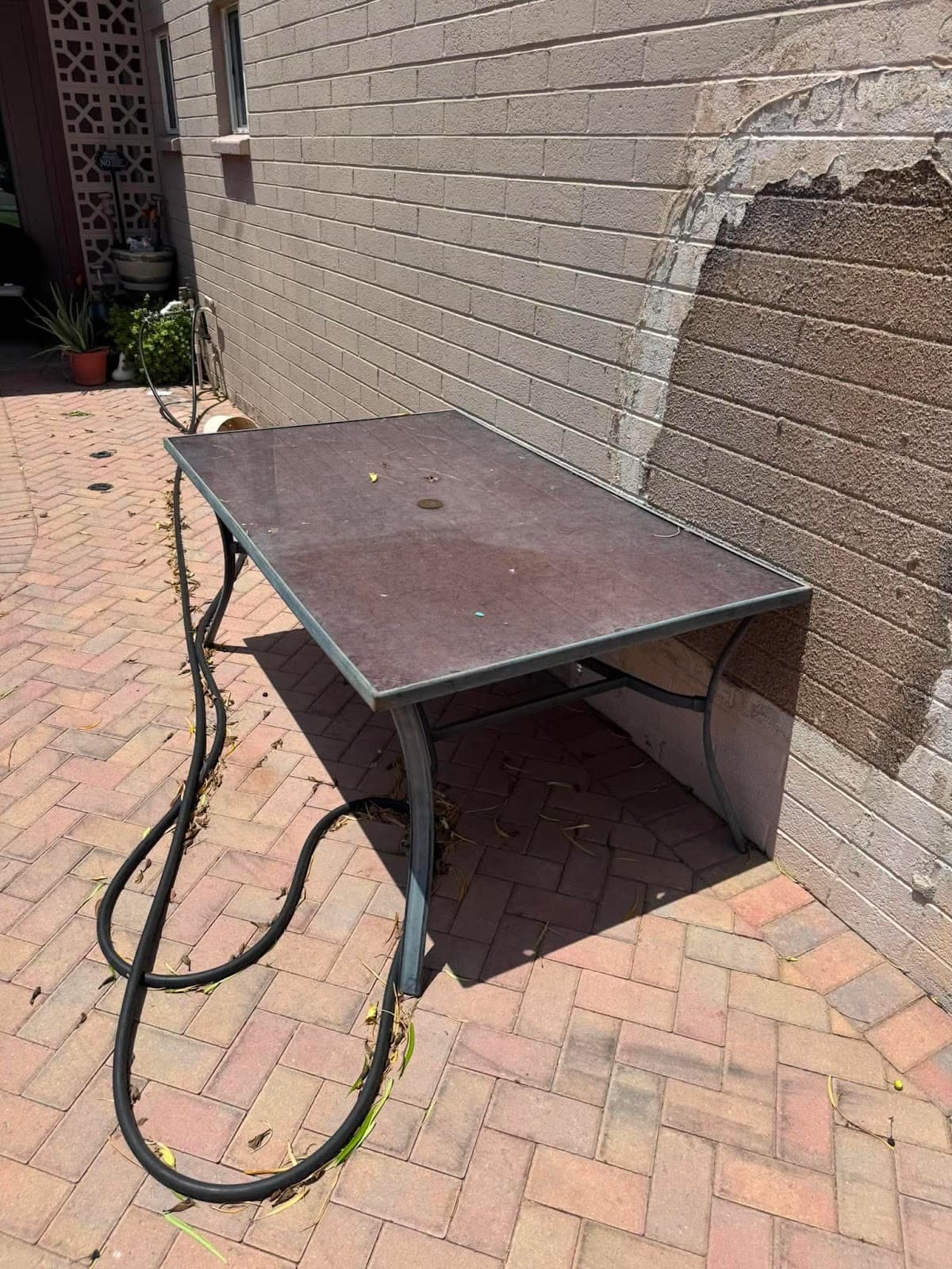Worn patio table removed from a backyard during a junk removal pickup