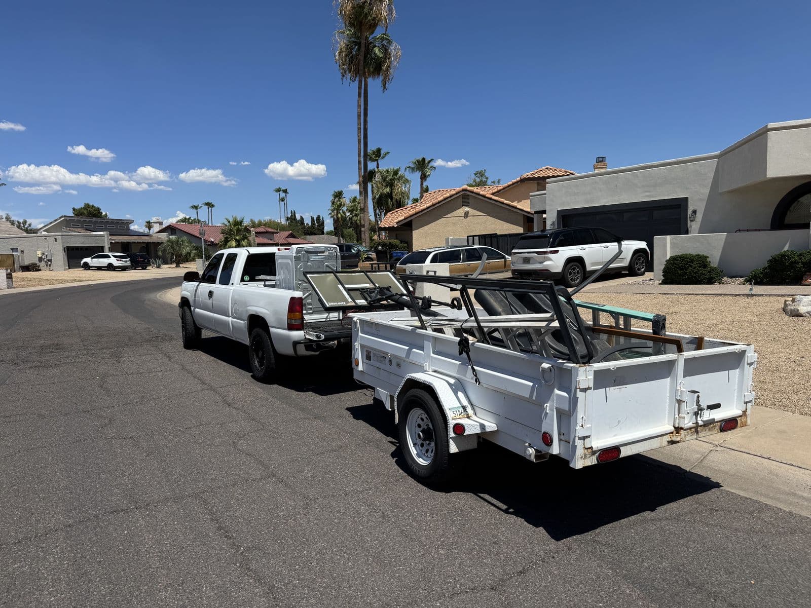 Sonoran Standard pickup truck and utility trailer loaded with a junk removal haul on an East Valley street
